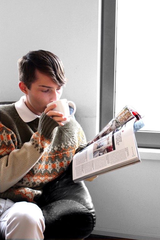 Mister Matthew trinkt Tee und trägt einen Männer Pullover für den Herbst