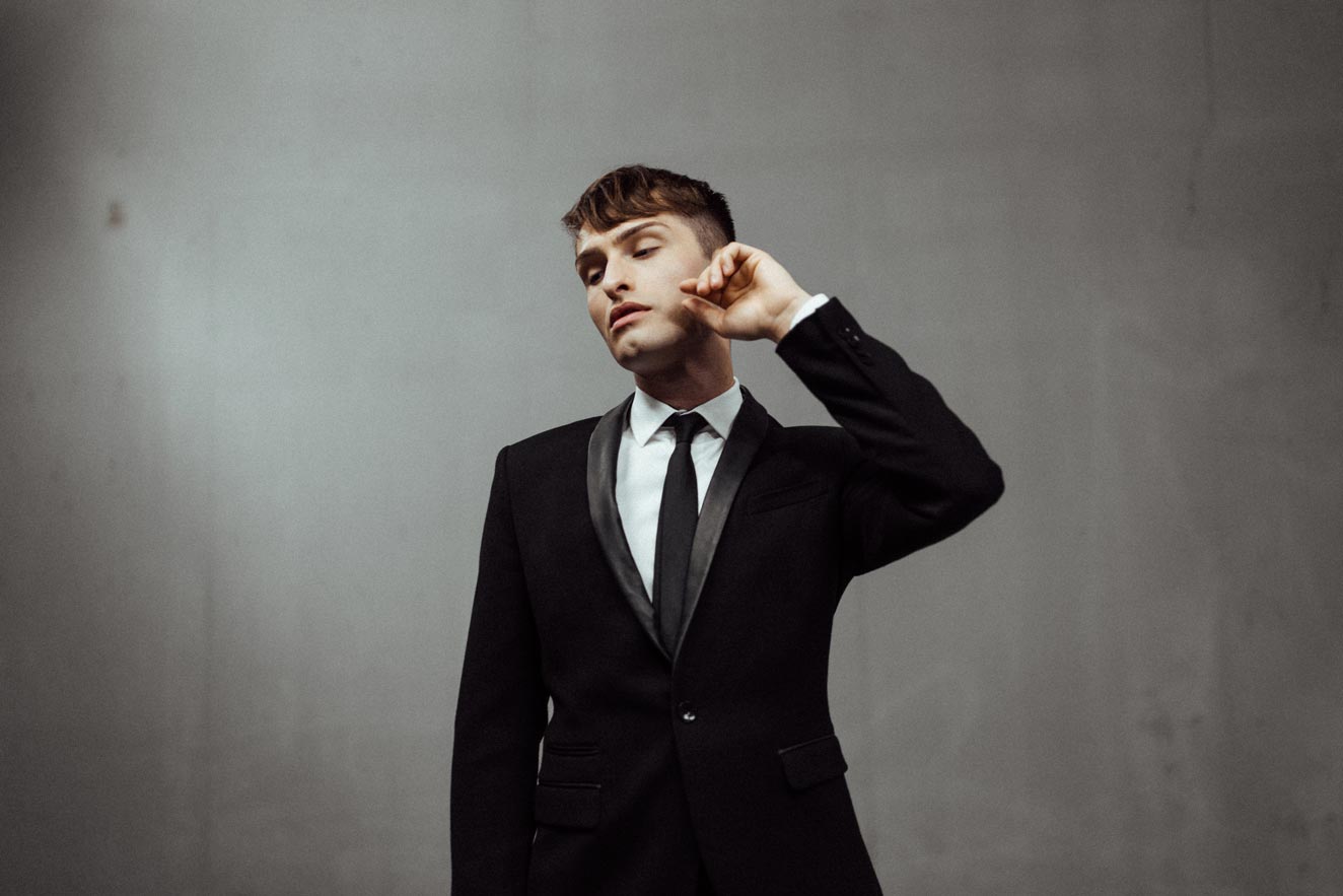 schwarze Anzug für Männer Mister Matthew vor grauer Wand Fashion Blog 1