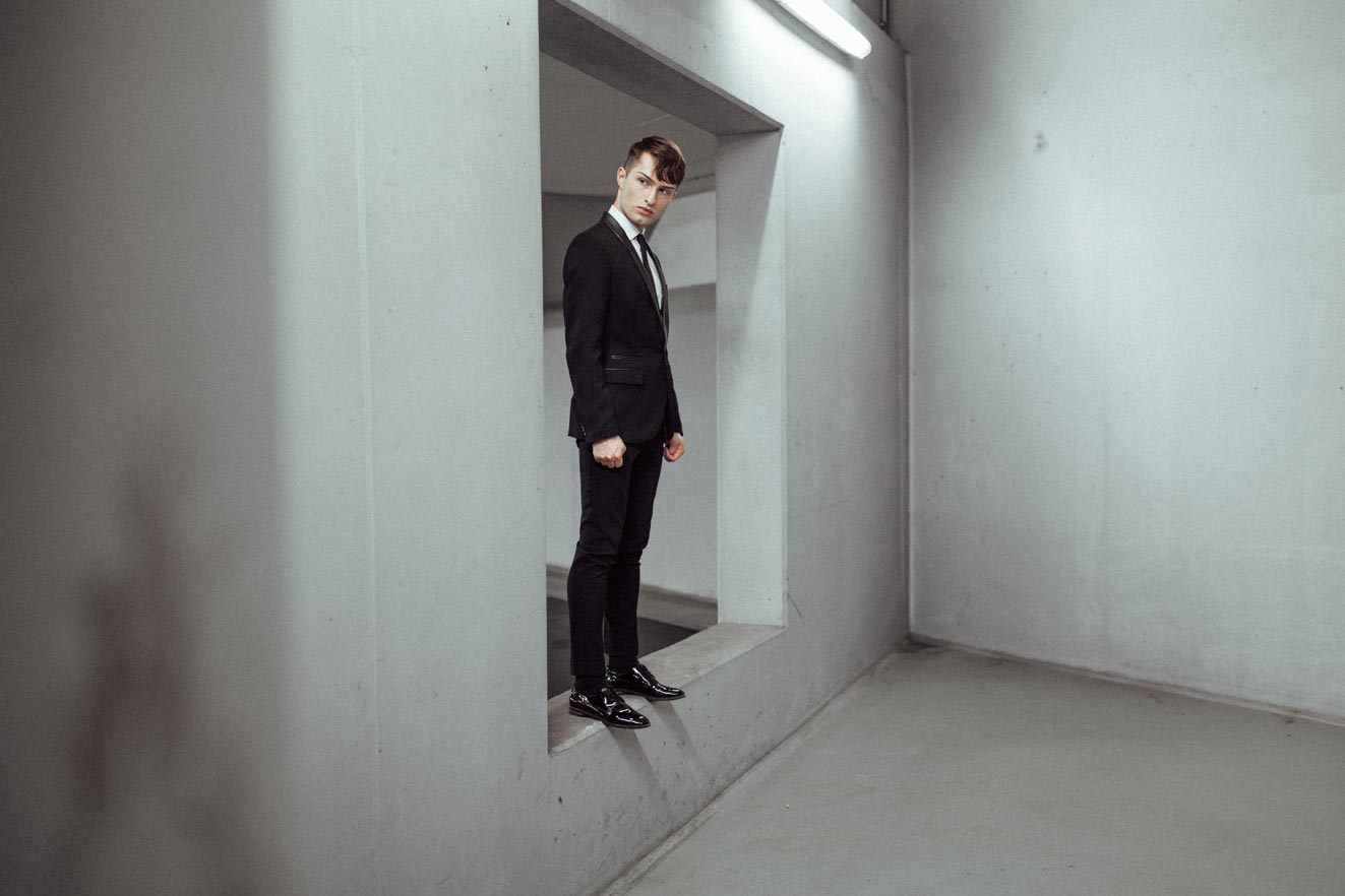 schwarze Anzug für Männer Mister Matthew vor grauer Wand Fashion Blog 10