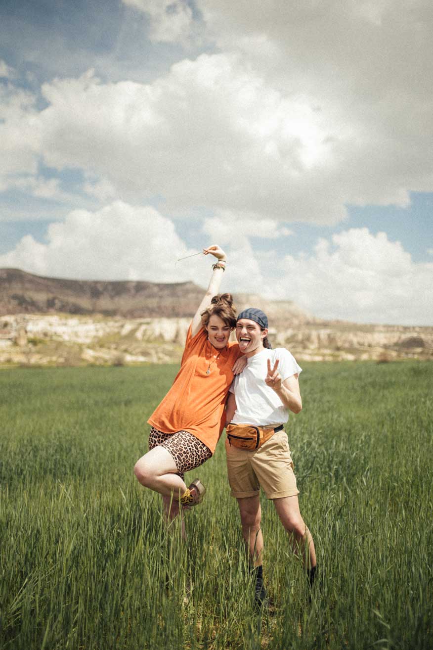 Vanessa Thiel Photography und Mister Matthew stehen in einer Graslandschaft in Kappadokien.