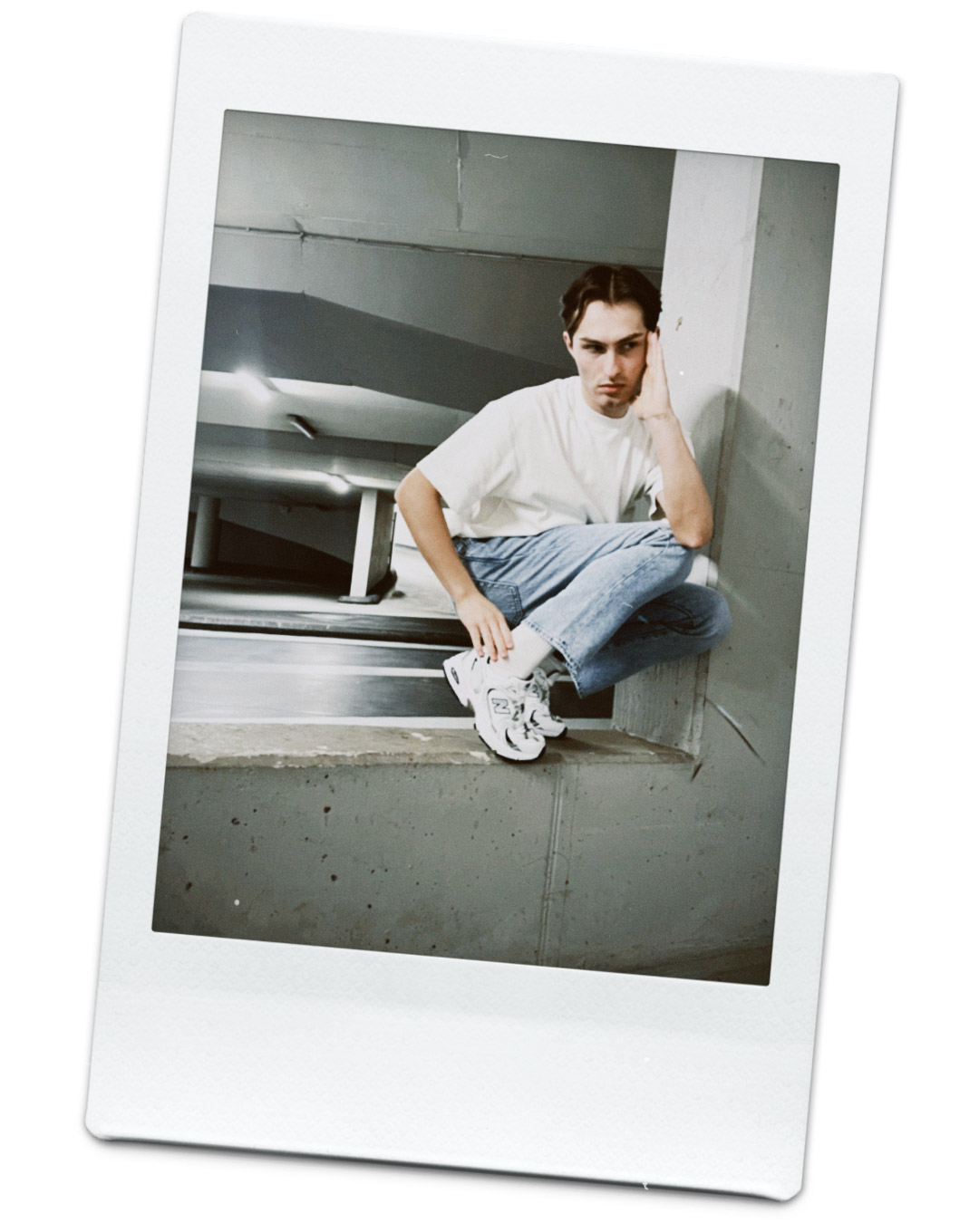 Weißes T-Shirt, blaue Jeans, Retro-Sneaker als Polaroid fotografiert