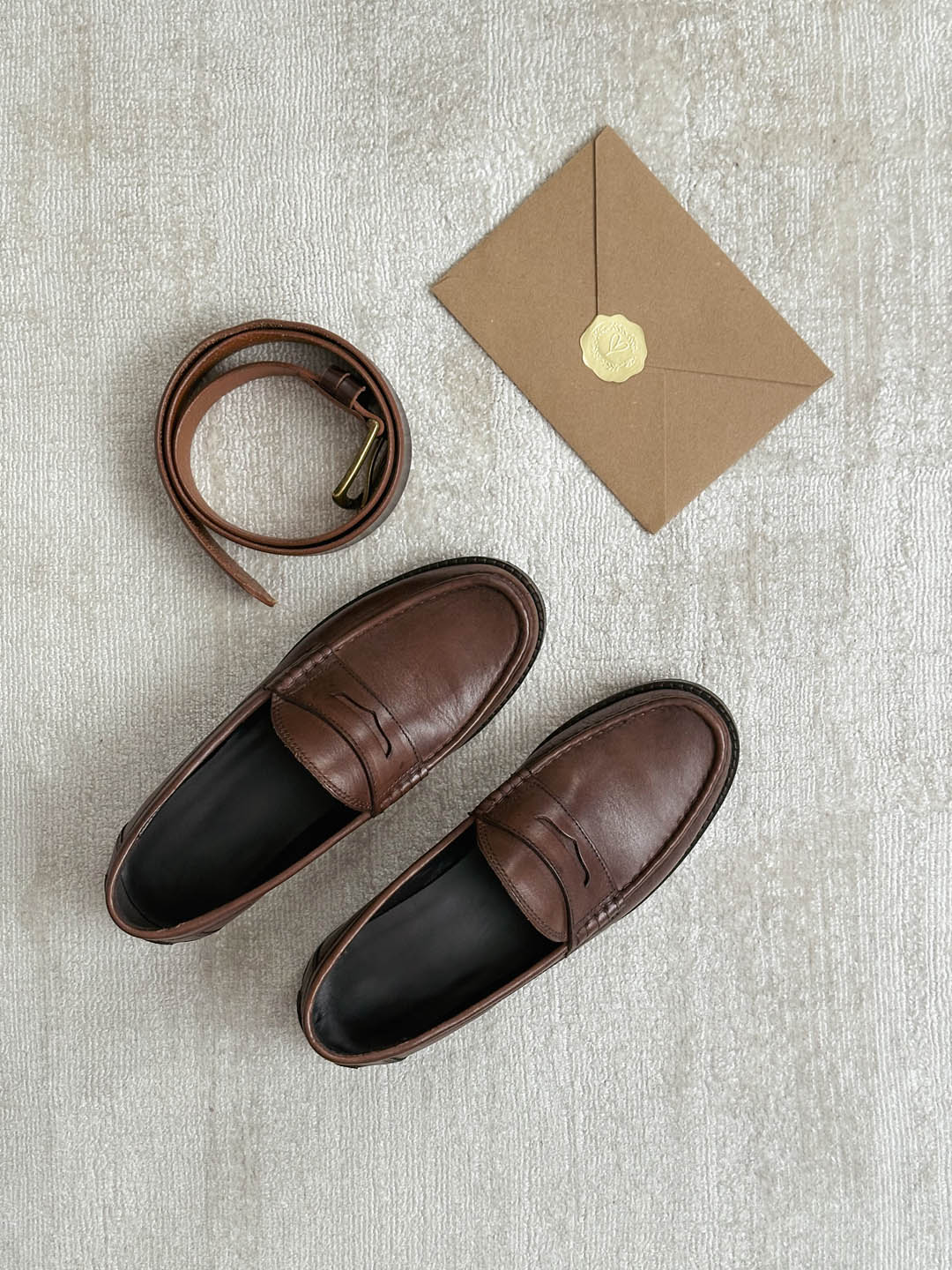Gürtel, Loafers und Einladung in Braun